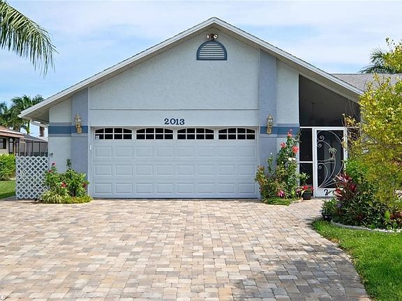 Front elevation featuring wide paver driveway