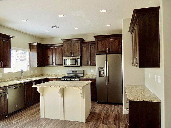 The fully-equipped kitchen features granite countertops, stainless appliances, gas stove, wood cabinets, built-in desk & a large pantry.