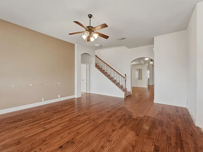 Family room with light wood-type flooring, hanging lights, and a ceiling fan