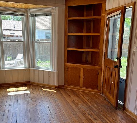 front door leads into living room with recessed lights & 2 built-in bookshelves with storage cabinets