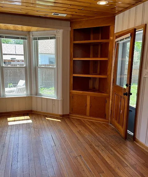 front door leads into living room with recessed lights & 2 built-in bookshelves with storage cabinets