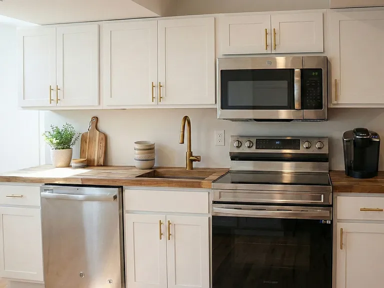 Modern kitchen with stainless steel oven, microwave, dishwasher, and updated finishes.