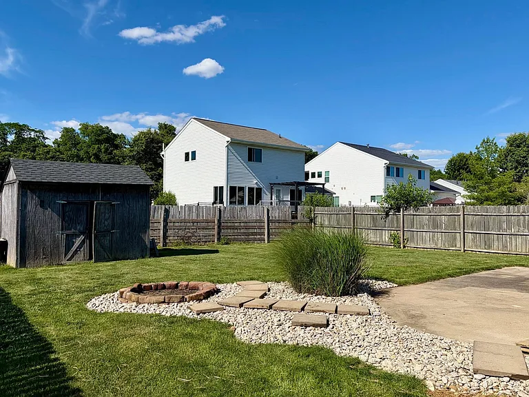 Fully fenced rear yard with large concrete patio and fire-pit, for peaceful and pleasant evening at home