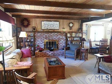 Open living room is airy and bright, newer carpet, and built-in bookcases.