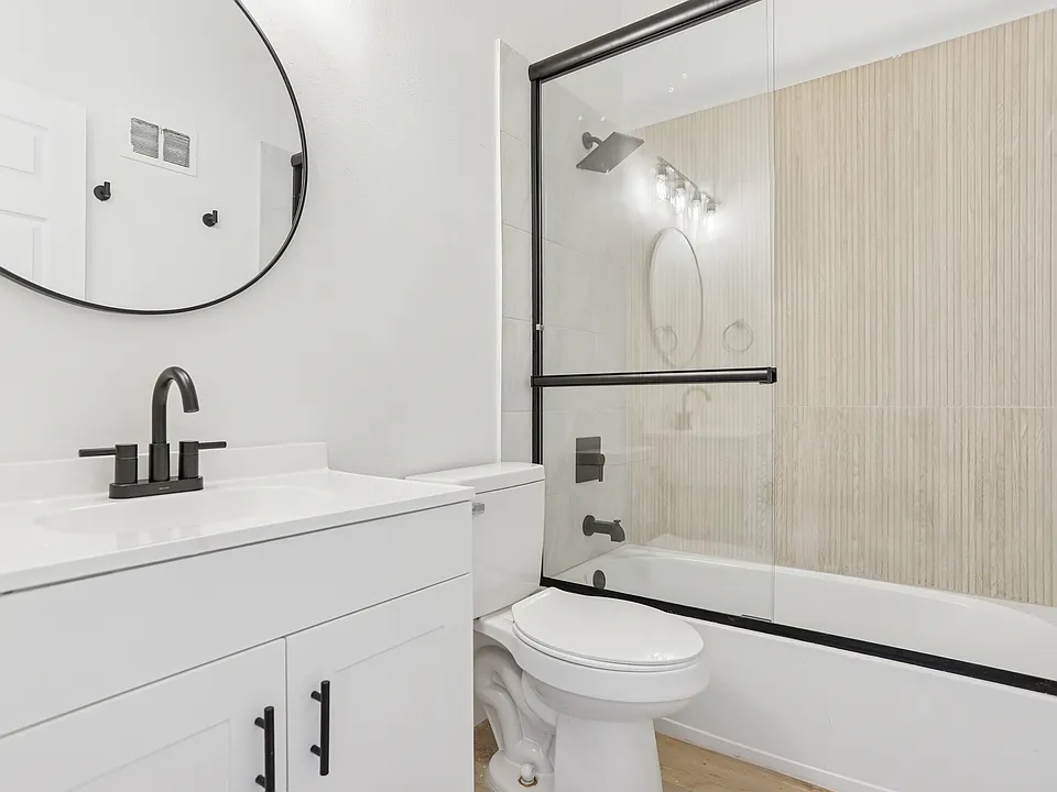 Exceptionally remodeled bathroom with two tone tile, sliding shower glass doors, no more shower curtains, new tub, bathroom vanity, light fixtures and towel hooks