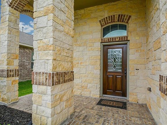Masterful design and modern luxury are uniquely embodied in this home with features like rough hewn stone and brick facade and beveled glass front door.