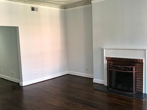 Great room/living room with fireplace, hardwood floors, and original tin ceiling