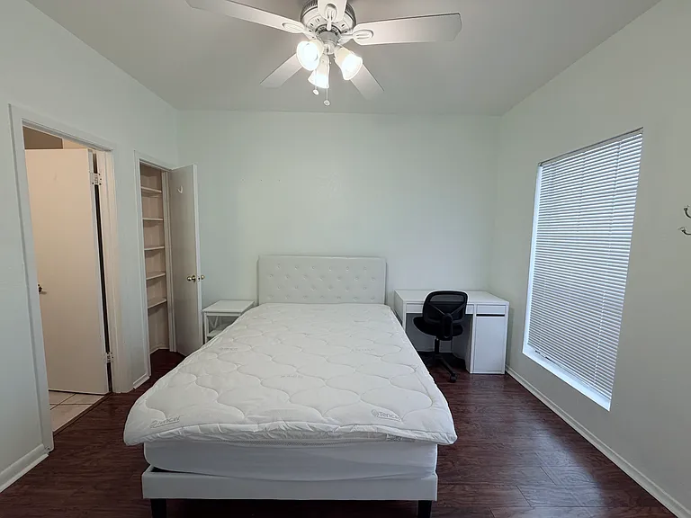 Well lighted 2nd bedroom compliments with a bed, a student desk and a night stand. It walks into the private bathroom on the left side.