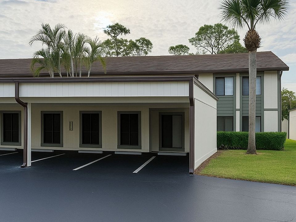 View of front of building. Unit has a covered parking spot and storage unit.