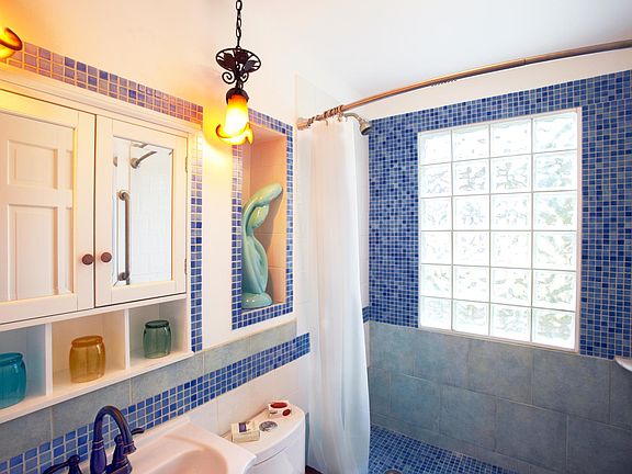 Bathroom with glass tile wall.