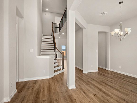 The entryway opens to a grand staircase and formal dining room