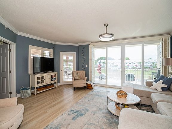 Living Room with double chaise sofa, smart TV, 8' sliding doors, shutters, LVP, seating for 6