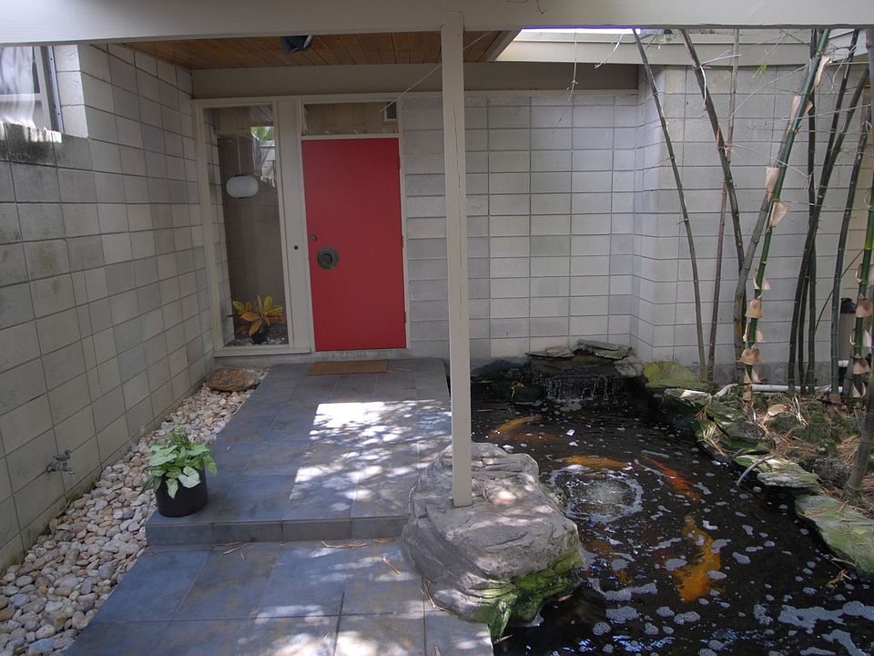 Covered enry walk with Koi pond and bamboo forest at entry from double carport