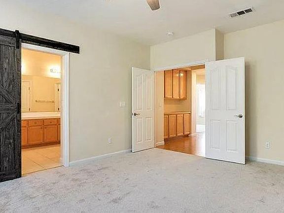 Master bedroom with large private bathroom, double doors, and barn door to bathroom.