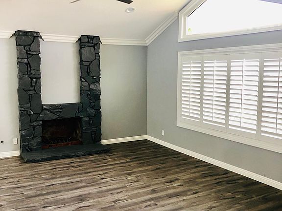 Living room with stainless steel ceiling fan and rock fireplace
