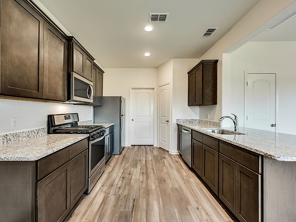 Enjoy stunning granite countertops and designer wood cabinetry in this kitchen.