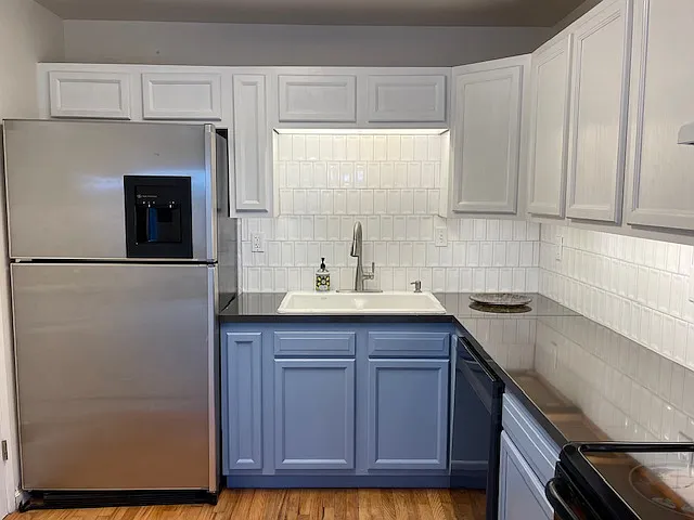 Kitchen with dishwasher, range stove, refrigerator/freezer, garbage disposal, dual bowl cast iron sink, pull down faucet, built in soap dispenser, under cabinet lighting.