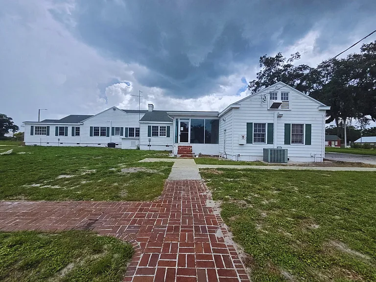 Charming exterior view with open green grass around the property