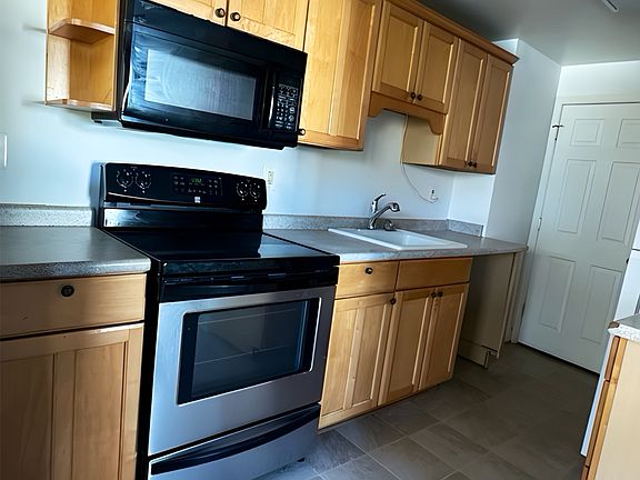 Spacious kitchen with ample cabinet storage, tile flooring, and updated appliances.