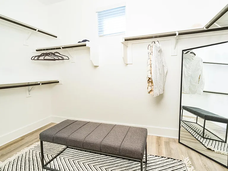 A spacious closet with built-in shelving and hanging space offers an organized layout designed to keep daily essentials neatly in place.