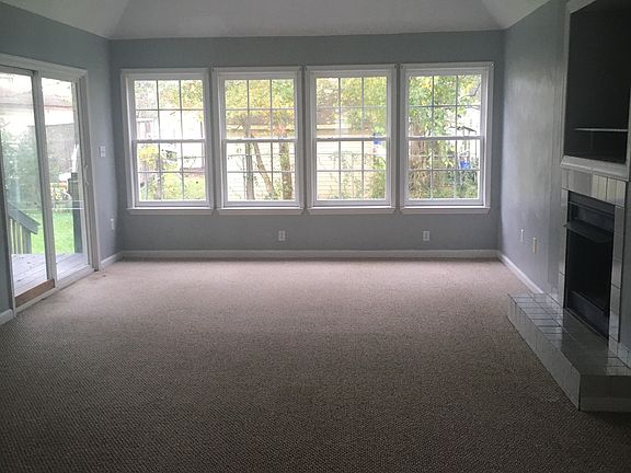 Family/Living room with lots of natural light from windows and patio door.