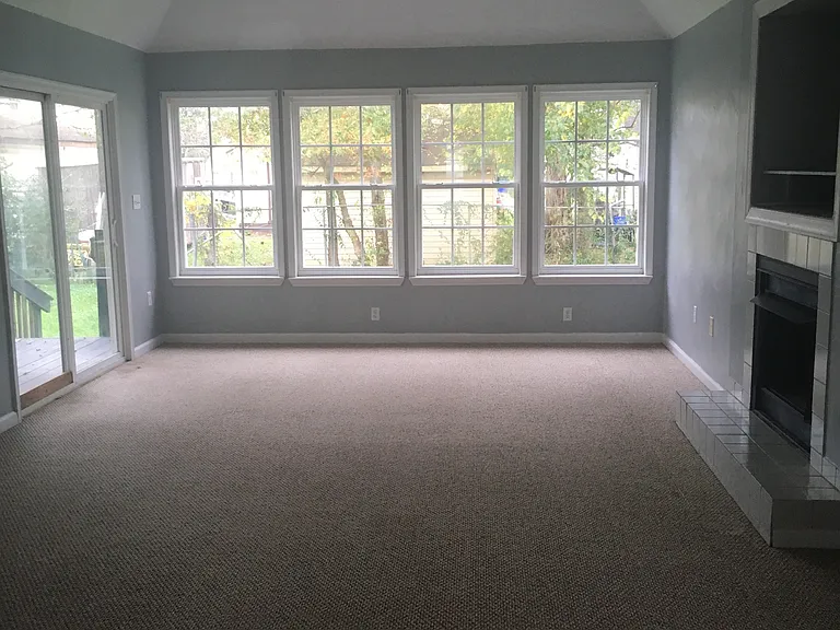 Family/Living room with lots of natural light from windows and patio door.