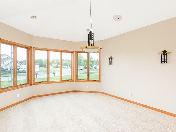 Main level living room or dining room with new carpet and a bay window. Bright space with lots of windows.