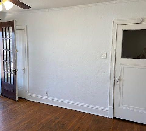 Living room with balcony door to the left and door from the stairway to the right