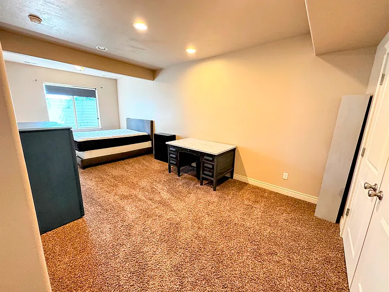 Large master bedroom. Includes Queen-size bed, dresser, desk, and large closet with built-in shelves.