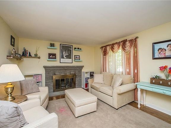 To the right of the front entry is the inviting living room, offering easy-to-match wall tones, a gas fireplace with stone surro