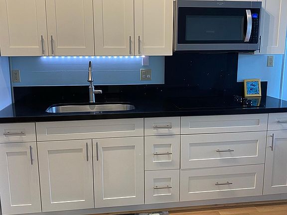 Fully equipped kitchen with quartz countertop, shaker cabinets with soft close drawers and doors. Electric radiant cooktop and microwave oven.