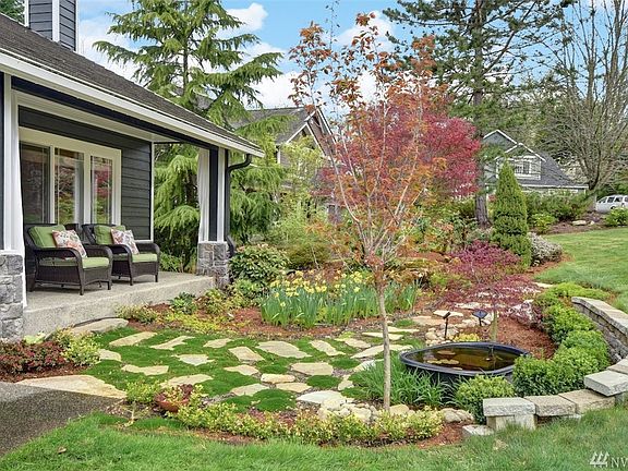 Set back from the quiet cul-de sac street on the covered porch, you can enjoy the artful landscape design created by the current owner.