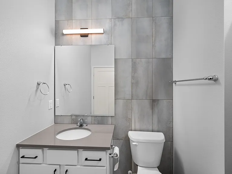 Modern bathroom with sleek design, featuring a stylish vanity, large mirror, and contemporary light fixture. Modern bathroom with sleek design, featuring a stylish vanity, large mirror, and contemporary light fixture.