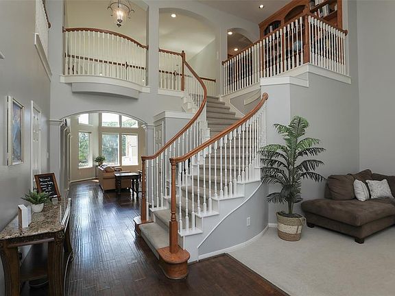 Dramatic entry with formal living to the right and a curved staircase that exudes charm.