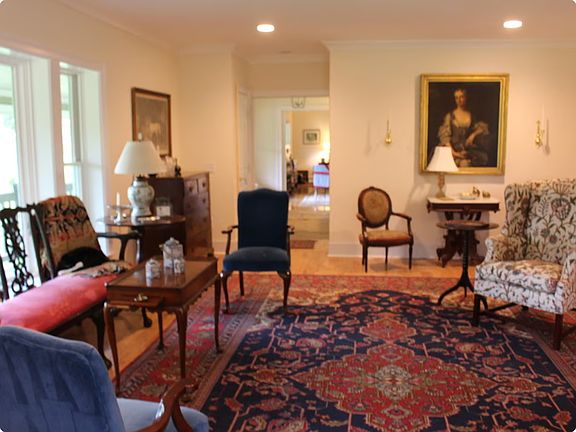 Spacious Living Room lovely antiques and views of pasture to south and east through large windows and French doors.