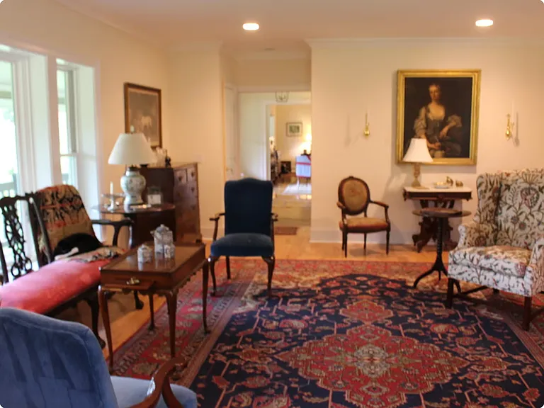 Spacious Living Room lovely antiques and views of pasture to south and east through large windows and French doors.