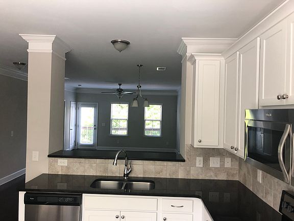 From kitchen to living room and balcony with tree line view.