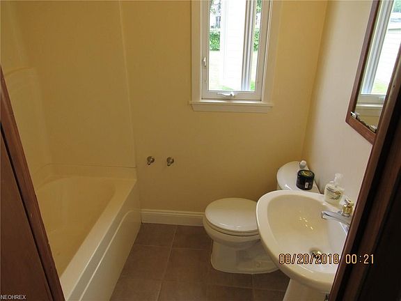 Cheery bathroom with ceramic tile floor.