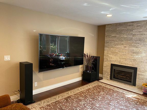 TV room and upgraded fireplace with floor to ceiling tiles