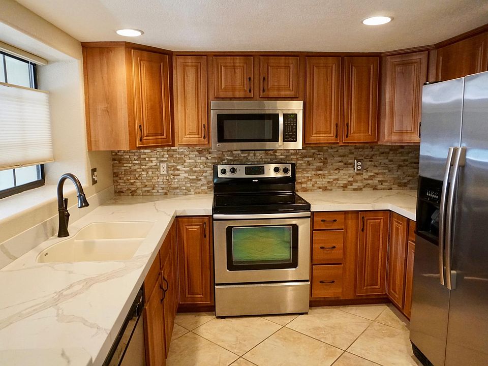Updated kitchen and cabinets, quartz countertops, beautiful decorative backsplash, recessed lights, large window and stainless steel appliances (new refrigerator and dishwasher December 2025).