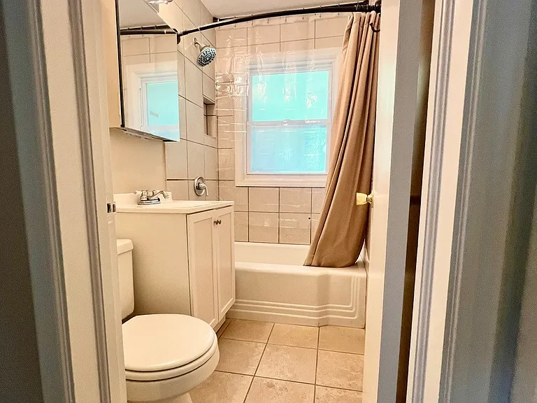 Bathroom features brand new lighting, mirrored vanity with built-in storage, large tub with newer tile surround and large shower head.