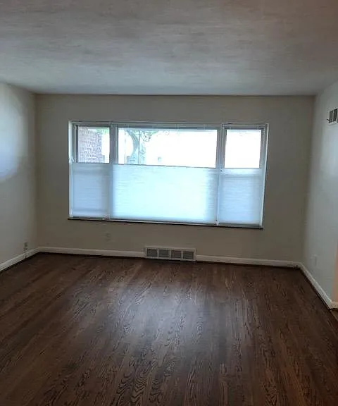 Front living room window with cellular shades that can be raised from bottom or top down.