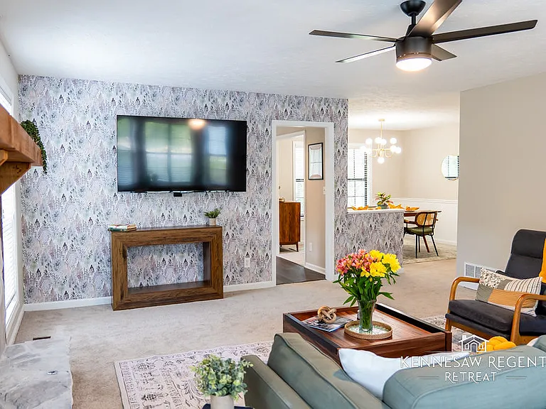 The room's neutral color palette is accented by subtle pops of color, creating a sophisticated and inviting atmosphere. A sleek, modern fireplace adds a touch of warmth and ambiance to the space.
