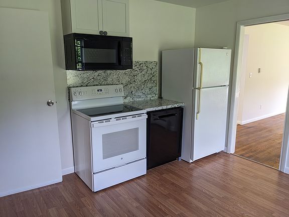 Kitchen with stove, dishwasher, frig, and microwave (door on left is to the cellar)