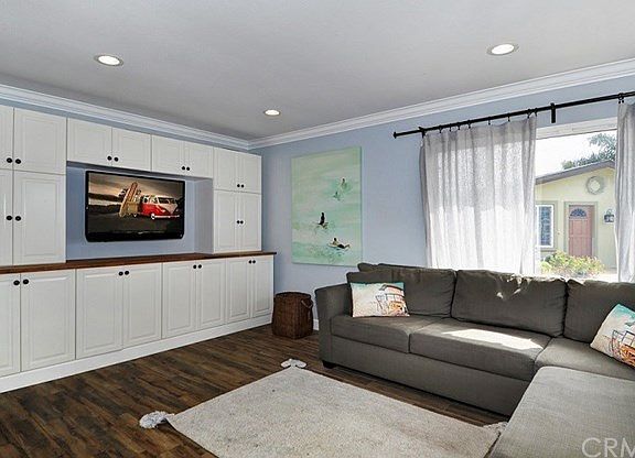 Living room with custom cabinetry, recessed lighting & crown molding!