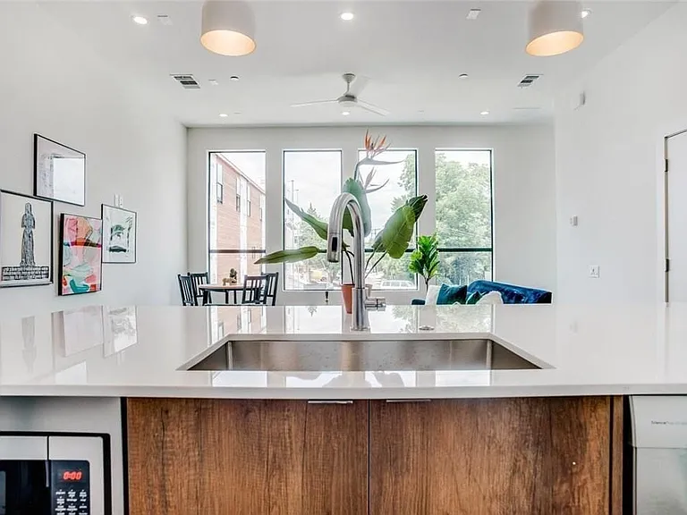 Expansive kitchen island featuring a stainless steel undermount sink and a high-arc faucet