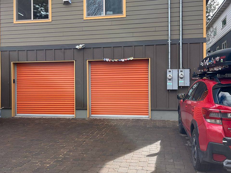 Top two windows are from the dining room and living room of the unit. Entrance to the ADU/apartment is to the far right in front of the red car.