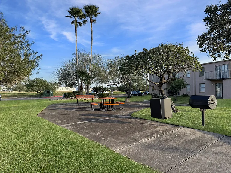 Community picnic space with tables and grill at Los Cedros Apartments in Brownsville, TX.