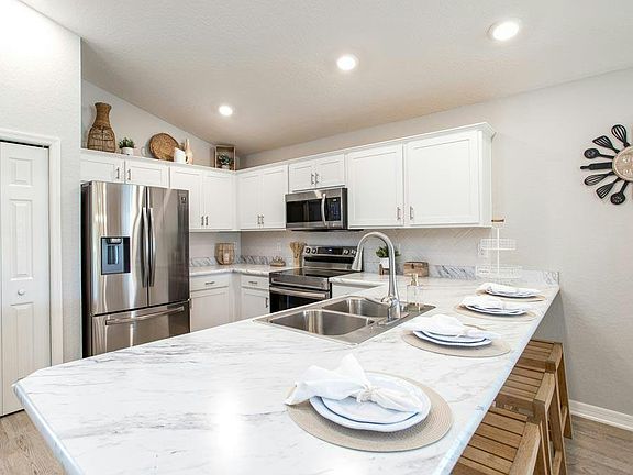 Your sunny and open kitchen includes a pantry, counter-height bar, and your choice of finishes - Ama