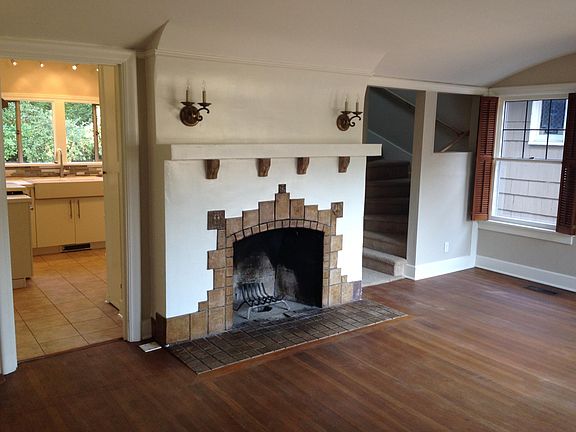 Lovely arts and crafts fireplace, built-ins and big windows grace the living room